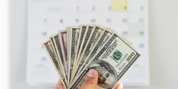 The 2026 SSI Boost: What It Means for Your Monthly Benefits Hand holding dollar bills with 2026 calendar, representing increased SSI benefits.